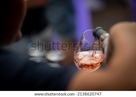 hand with a glass of rosé wine at a wine tasting Royalty-Free Stock Photo #2138620747