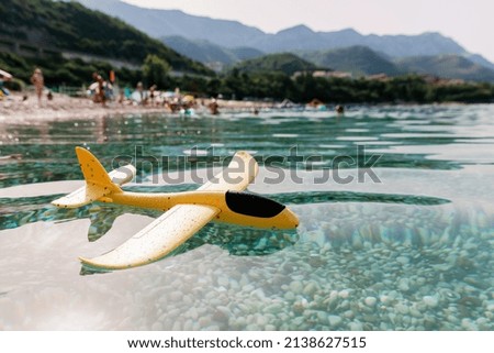 Yellow toy plane lying on the water