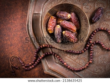 Arabian dates in an antique metal bowl with Islamic prayer beads. Ramadan Kareem- Muslim festival objects and background.
 Royalty-Free Stock Photo #2138635425