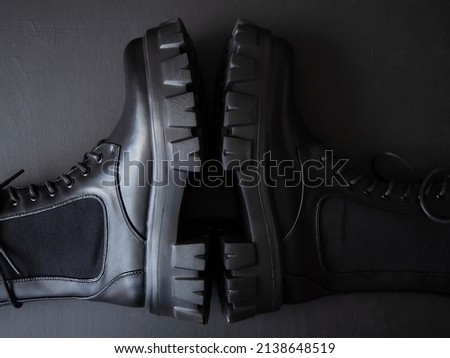 Black leather lace-up boots. Fashionable, stylish collection of women's shoes. Black background.