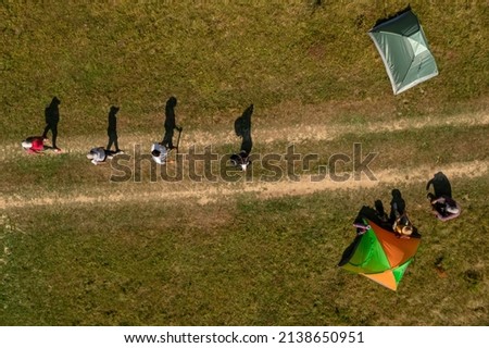 Group of tourists near tents in campsite, top aerial view. Drone photography