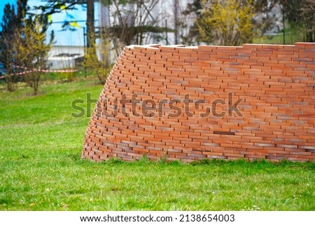 Brick wall sculpture at Ariana Park at City of Geneva on a cloudy spring day. Photo taken March 18th, 2022, Geneva, Switzerland.