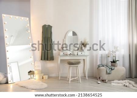 Large mirror with light bulbs and dressing table in stylish room. Interior design Royalty-Free Stock Photo #2138654525