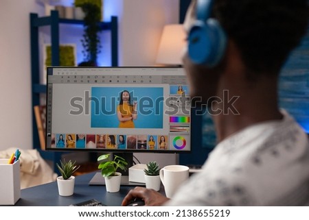 Photographer editor editing photos using retouching software working at picture contrast sitting at desk in creativity studio. Professional illustrator making digital correction. Remote work