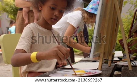Outdoor painting art class for kids. Children paint with paints during the open air. Development of creativity and creative thinking. 