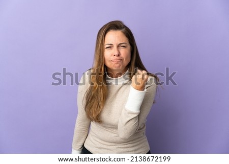 Middle age Brazilian woman isolated on purple background with unhappy expression