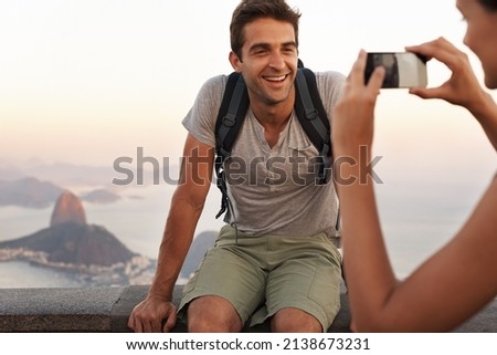 Capturing a memory. A young tourist having his picture taking while backpacking.