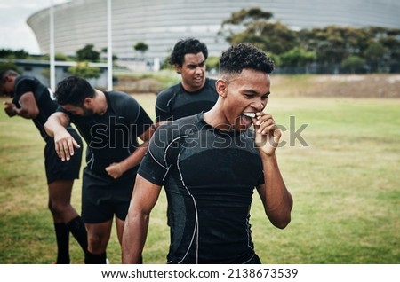 Its half-time. Cropped shot of a handsome young rugby player removing his mouthguard during half-time on the field. Royalty-Free Stock Photo #2138673539