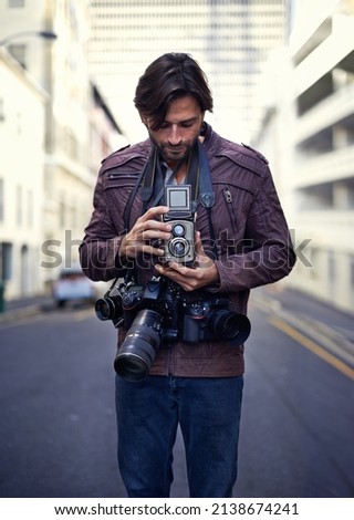 Photography is my passion. Shot of a handsome young photographer at work in the city.