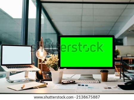 Ready to take this business online. Shot of a desktop computer with a green screen on a table inside of a office during the day.