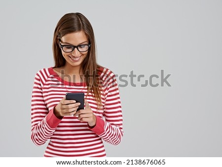 What filter should I use. Studio shot of an attractive young woman using a smartphone on a grey background.