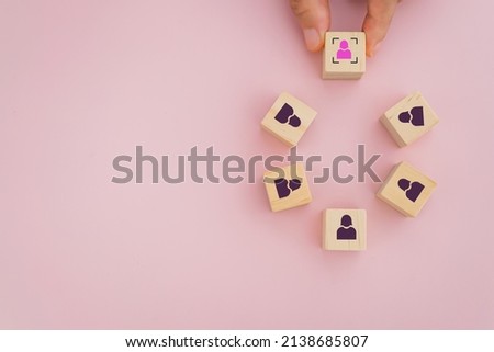 senior woman's hand choose different woman icon on wooden cube block out of the other black for leadership, outstanding, smart vision, people rights,  international women's day concept