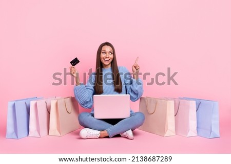 Full body photo of young girl indicate finger empty space select recommend use laptop shop card isolated over pink color background