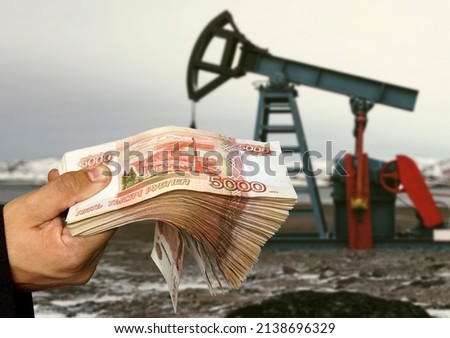 concept of selling minerals for Russian rubles. The shadow of the oil rig against the background of Russian money. Earn money from mining gas and oil energy resources Royalty-Free Stock Photo #2138696329