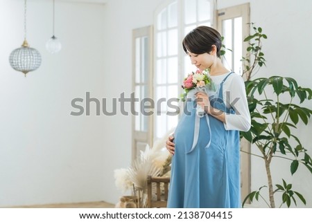 Asian pregnant woman in modern room.