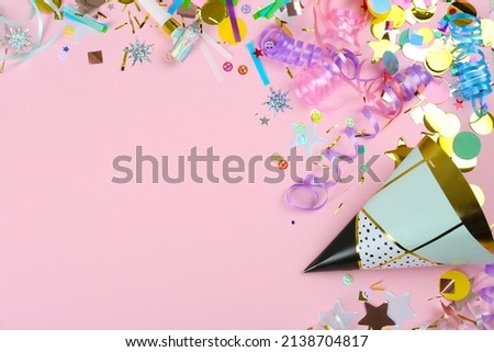 Colorful serpentine streamers, party hat, horn and confetti on pink background, flat lay. Space for text