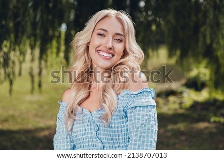 Portrait of attractive cheerful pretty wavy-haired girl enjoying good weather springtime weekend on fresh air outdoors.