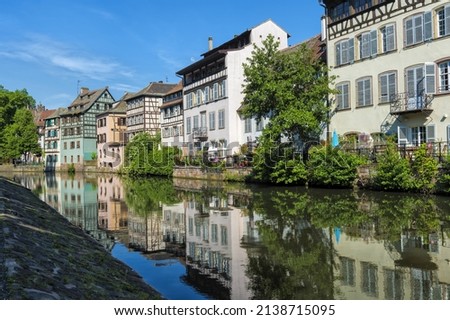 Timbered Houses reflecting in the ILL canal along the riverbank of the Petite France, Strasbourg, Alsace, Bas-Rhin Department, France Royalty-Free Stock Photo #2138715095