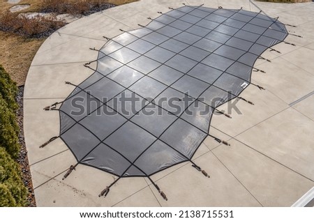 in the ground pool has been winterized with a pool cover Royalty-Free Stock Photo #2138715531