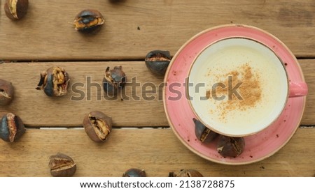 Salep and chestnuts in pink coffee mug on wooden table Royalty-Free Stock Photo #2138728875