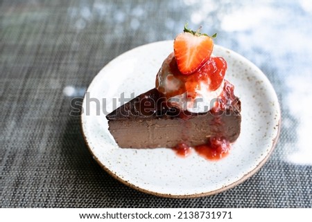 Chocolate cake strawberry cream. Cake cream and strawberry on concrete background. Scoop and eat strawberry cake in the cafe.