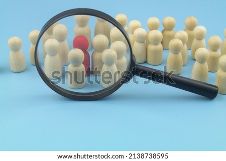 Many wooden people figures  under magnifying glass. Hire workers concept. Royalty-Free Stock Photo #2138738595