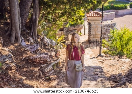 Woman tourist walking together in Montenegro. Panoramic summer landscape of the beautiful green Royal park Milocer on the shore of the the Adriatic Sea, Montenegro