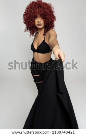 Curly haired woman in studio with a fashion photoshoot