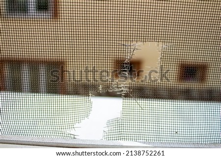 Closeup photo of broken mosquito screen.