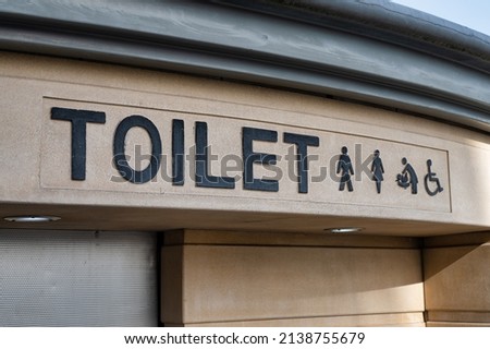 Sign for public toilets with a simble of a man, women, baby and disabled person