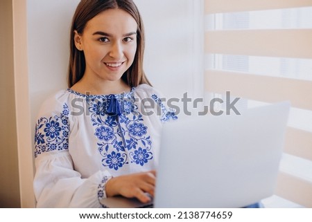 Young ukrainian woman wearing vyshyvanka working from home