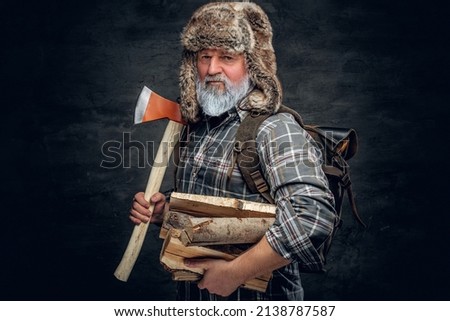 Old man woodman holding hatchet and stack of lumber Royalty-Free Stock Photo #2138787587