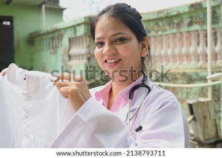 An Indian female doctor holding white laundary