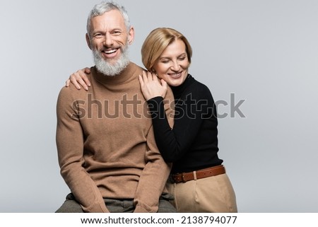 Blonde woman in turtleneck hugging mature husband isolated on grey Royalty-Free Stock Photo #2138794077