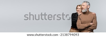 Middle aged woman hugging bearded husband isolated on grey, banner Royalty-Free Stock Photo #2138794093