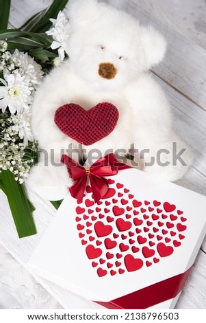 Valentine's day gift, teddy bear with a heart, a box of pralines and a bouquet 