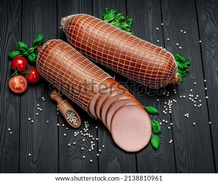 Italian thick boiled sausage on a dark background. From different types of meat. Photo for the menu. Advertising.