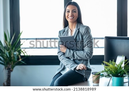 Shot of beauty business woman using her digital tablet while sitting on a desk in a modern startup office. Royalty-Free Stock Photo #2138818989