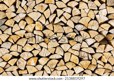 Stacked chopped wood close-up texture. Firewood storage background. Stocks of wooden logs. Chopping wood for a fireplace. Woodpile with firewood with visible wooden texture.