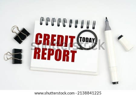 Business concept. On a white surface lies a marker, clips and a notebook with the inscriptions Today and CREDIT REPORT
