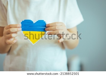 Patriot of Ukraine! Flag of Ukraine in the shape of a heart in a man's hand. National holiday of Ukraine. The concept of ending the war in Ukraine