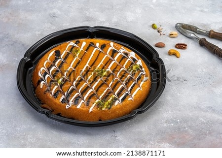 Black Plastic plate with oriental honey sweets  baklava on grey wooden background
Plastic container with oriental honey sweets  fresh strawberry with milk on a wooden table  black background Royalty-Free Stock Photo #2138871171