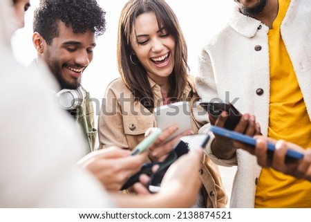 Young group of people using mobile phone outdoors - Addicted diverse friends holding smartphones sharing social media content on digital network app - Youth and technology concept - Focus woman face Royalty-Free Stock Photo #2138874521