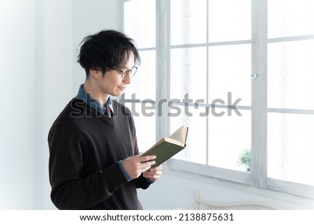 Asian man reading a book in the room