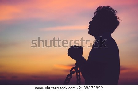 Silhouette man with chain Freedom, Worship and Pray.Repent of wrong doing.Prisoner with break chain power of prayer sunset background.Pray faith hope.Forgive revival.Sacrifice and .Juneteenth.African. Royalty-Free Stock Photo #2138875859