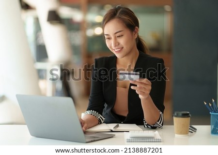 Woman using shopping web site by laptop computer and payment by credit card.