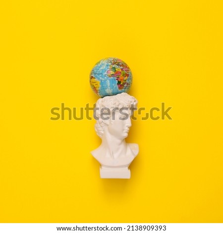 Antique David bust with globe on yellow background. Conceptual pop. Minimal still life. Creative idea. Flat lay