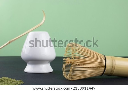 Matcha tea powder, whisk, spoon on color background, copy space. Japanese matcha green tea ceremony. 