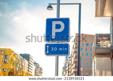 Road sign allowing parking for 30 minutes in a developing city area in Copenhagen, Denmark