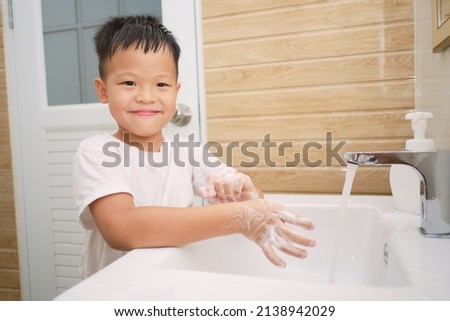 Handwashing, Cute little Asian 5 years old kindergarten boy child washing hands by himself on sink and water drop from faucet in toilet, Hygiene Habits for Kids concept, Soft and selective focus Royalty-Free Stock Photo #2138942029